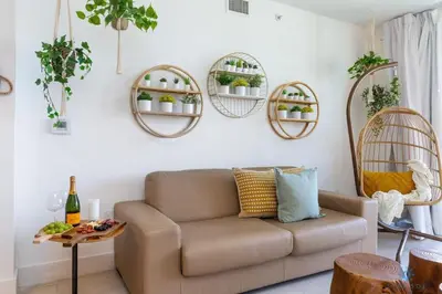 a living room with a couch and some potted plants at Tropical Apartment - Balcony - Resort with Pool and Gym in Hallandale Beach