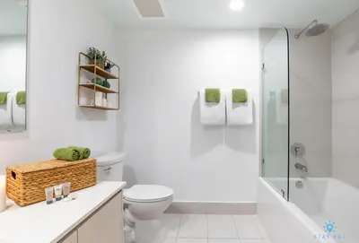 a white bathroom with a toilet and a shower at Tropical Apartment - Balcony - Resort with Pool and Gym in Hallandale Beach