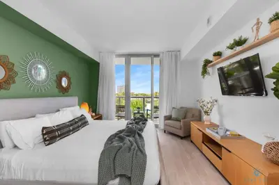 a bedroom with a large white bed and a television at Tropical Apartment - Balcony - Resort with Pool and Gym in Hallandale Beach