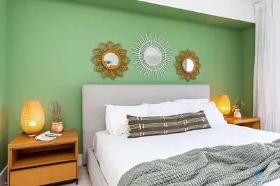 a bedroom with a bed and two mirrors on the wall at Tropical Apartment - Balcony - Resort with Pool and Gym in Hallandale Beach