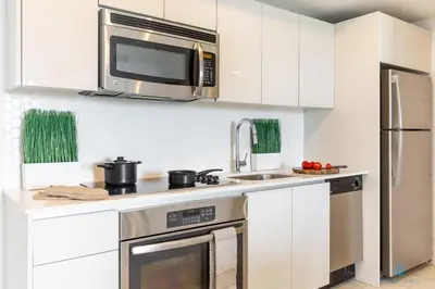 a kitchen with a stainless steel stove and a microwave at Tropical Apartment - Balcony - Resort with Pool and Gym in Hallandale Beach