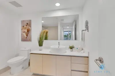 a bathroom with a sink and a toilet and a mirror at MODERN Resort Modern apartment 2 BR 2 BR POOL in Hallandale Beach