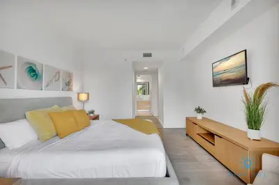 a bedroom with a large white bed with yellow pillows at MODERN Resort Modern apartment 2 BR 2 BR POOL in Hallandale Beach