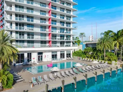 a resort pool with lounge chairs and a large building at MODERN Resort Modern apartment 2 BR 2 BR POOL in Hallandale Beach
