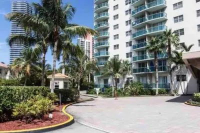 a large apartment complex with palm trees and a driveway at Ocean Reserve 222 STR-2158 in Miami Beach