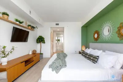 a bedroom with a large bed and a tv at Tropical Apartment with Balcony - Pool - Up To 4 - Gym in Hallandale Beach