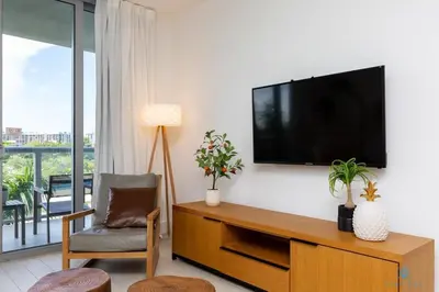 a living room with a flat screen tv on a wall at Tropical Apartment with Balcony - Pool - Up To 4 - Gym in Hallandale Beach