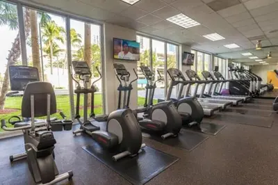 a gym with rows of treadmills and elliptical machines at Breathtaking ocean view! 15th floor in Miami Beach