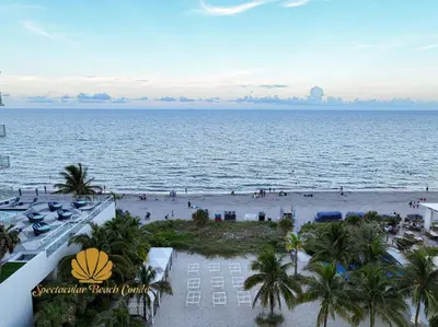 a view of the beach from the balcony of a resort at Oceanfront Luxury Condo - Private Beach Access, Pool & Game Room in Hollywood