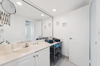 a bathroom with a sink and a large mirror at Oceanfront Luxury Condo - Private Beach Access, Pool & Game Room in Hollywood