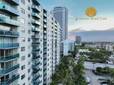 a view of a tall building with palm trees at Oceanfront Luxury Condo - Private Beach Access, Pool & Game Room in Hollywood