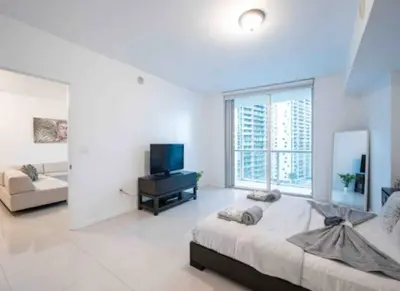 a bedroom with a large bed and a television in it at Vacation Apartment in Miami in Miami