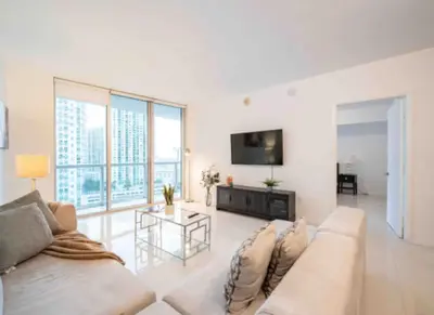 a white living room with a couch and a table at Vacation Apartment in Miami in Miami