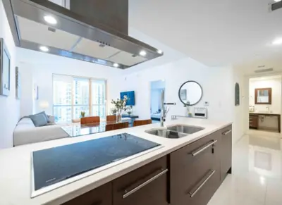 a kitchen with a sink and a living room at Vacation Apartment in Miami in Miami