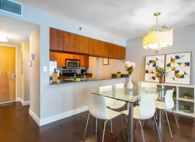 a dining room and kitchen with a glass table and white chairs at Modern Vacation Apartment in Miami in Miami