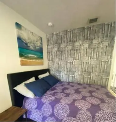 a bedroom with a purple bed and a wall at Small House Near Airport Beach - Wynwood in Miami