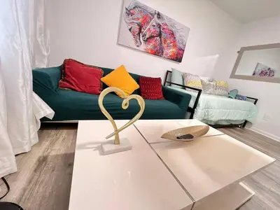 a living room with a green couch and a table at Small House Near Airport Beach - Wynwood in Miami
