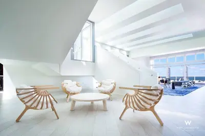 a living room with chairs and a table and stairs at 1 BR at Fort Lauderdale in Fort Lauderdale