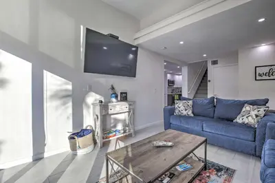 a living room with a blue couch and a tv at Canal-Front Condo Walk to Downtown Ft Lauderdale! in Fort Lauderdale