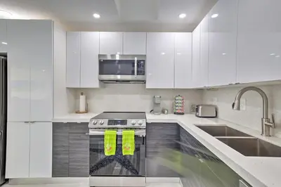 a white kitchen with a stove and a microwave at Canal-Front Condo Walk to Downtown Ft Lauderdale! in Fort Lauderdale