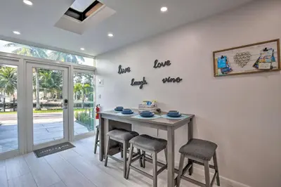 a dining room with a table and two stools at Canal-Front Condo Walk to Downtown Ft Lauderdale! in Fort Lauderdale