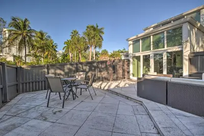 a patio with chairs and a table in front of a house at Canal-Front Condo Walk to Downtown Ft Lauderdale! in Fort Lauderdale
