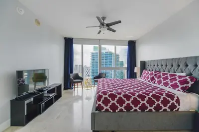 a bedroom with a large bed with a purple bedspread at Wonderful 2/2 Condo at Icon Brickell With Pool in Miami