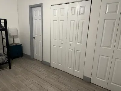 a room with two white doors and a tile floor at Bekahouse Hostel with parking, backyard and laundry in Miami