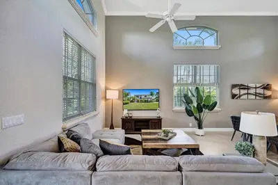 a living room with a couch and a tv at Spacious home wprivate pool game room in Plantation