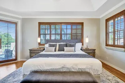 a bedroom with a large bed and two windows at Spacious home wprivate pool game room in Plantation