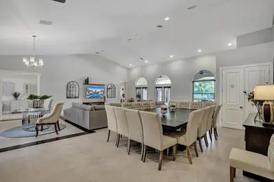 a dining room and living room with a table and chairs at Villa wpool mini-golf firepits in Davie