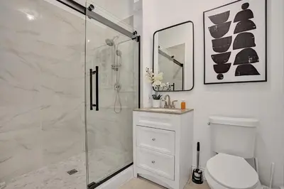 a white bathroom with a shower and a toilet at Villa wpool mini-golf firepits in Davie