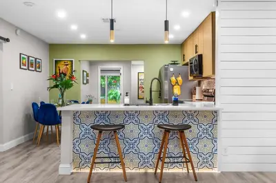 a kitchen with a counter and two stools at a bar at Swim, Dine, and Relax - Your private paradise awaits in Fort Lauderdale