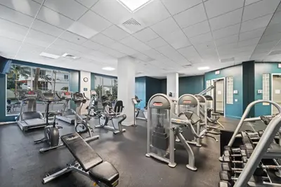 a gym with several treadmills and cardio machines at Hollywood Beachfront Condo, Steps to Ocean, Pool & Game Room in Hollywood