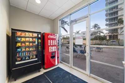a cocacola soda machine in a room with a window at Hollywood Beachfront Condo, Steps to Ocean, Pool & Game Room in Hollywood