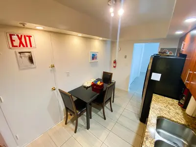 a dining room with a table and a refrigerator at Hollywood Beachfront Condo, Steps to Ocean, Pool & Game Room in Hollywood