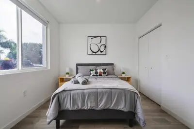 a bedroom with a bed and a large window at Amazing Townhouse 15 minutes from the Beach in Miami