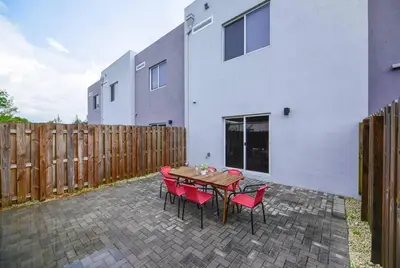a patio with a table and chairs and a building at Amazing Townhouse 15 minutes from the Beach in Miami