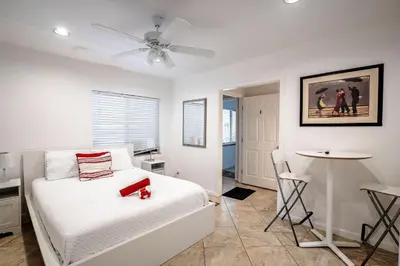 a white bedroom with a bed and a table at B efficiency Off Las Olas on water free kayaks in Fort Lauderdale