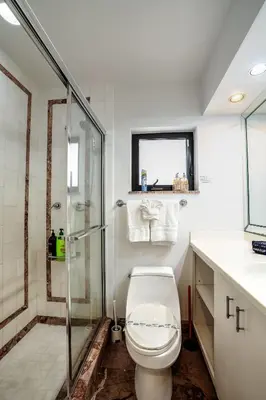 a bathroom with a toilet and a glass shower at B efficiency Off Las Olas on water free kayaks in Fort Lauderdale