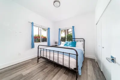 a bedroom with a bed and two windows at Pool Boutique Villa by the Beach 1 in Hallandale Beach