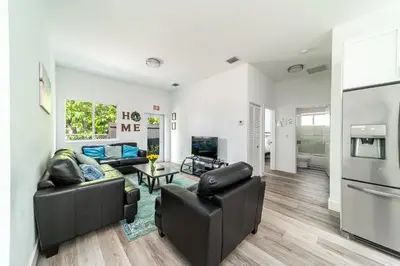 a living room with two couches and a tv at Pool Boutique Villa by the Beach 1 in Hallandale Beach
