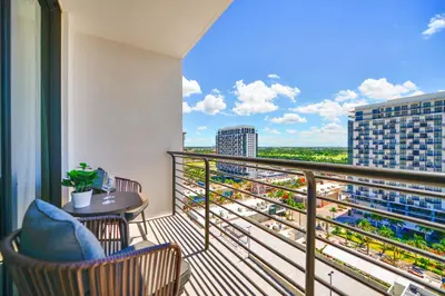 a balcony with a table and chairs and a view at Modern Hotel with Pool & Gym in Prime Doral Location in Miami