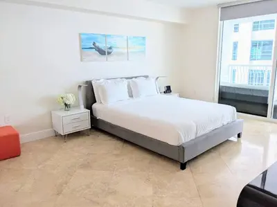 a white bedroom with a large bed and a window at Condo in Brickell Business District in Miami