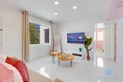 a living room with a couch and a tv at Free Parking, Bay View, Pool, Step To Beach in Hollywood