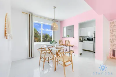 a dining room with pink walls and a table and chairs at Free Parking, Bay View, Pool, Step To Beach in Hollywood