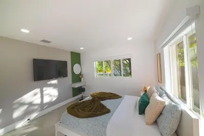 a white room with a bed and a tv at Heated pool in a Precious House close to Zoo Parks and Arts in Cutler Bay