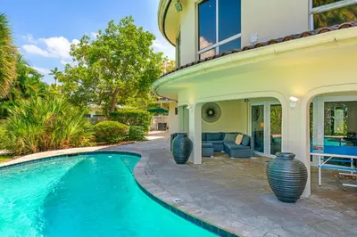 a house with a swimming pool in front of a house at Waterfront Retreat: 7BR Villa with Pool Firepit in Fort Lauderdale