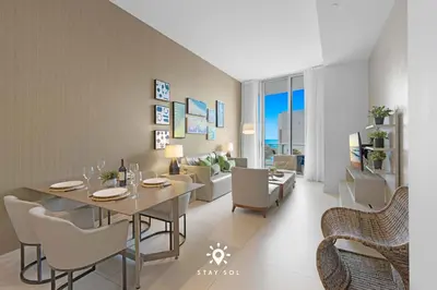 a dining room and living room with a table and chairs at Beachfront Condo - Amazing Pool - Oceanview Balcony in Hollywood