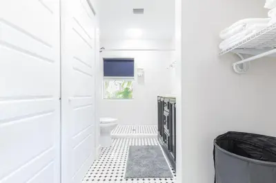 a white bathroom with a toilet and a door at Fun Family-Friendly Poolside Escape Near Beach in Dania Beach